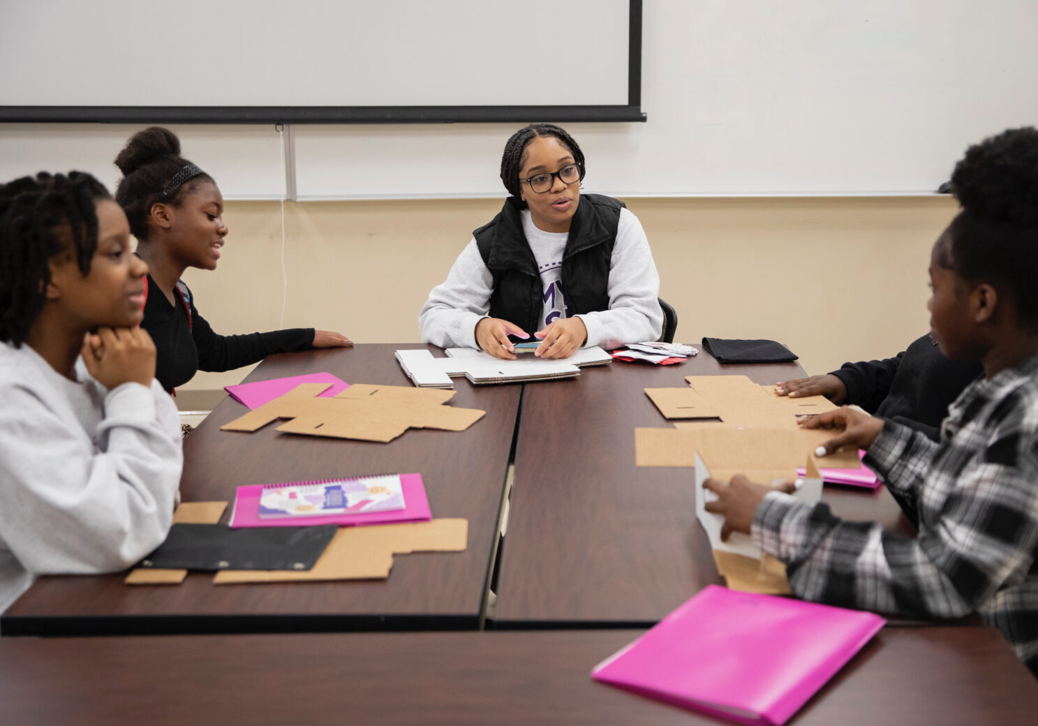 Mentor speaking with mentees at a table.
